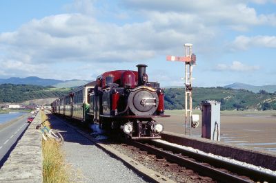 Over the Cob
Double Fairlie "Merddin Emris" beim Einfahrtssignal des Bahnhofes Porthmadog. Der Damm "The Cob" trennt das Mündungsdelta des Flusses Glaslyn vom Meer ab und schon seit 1836 führen die Schmalspurgleise über ihn hinweg nach Boston Lodge, wo im Hintergrund die Werkstätten der Bahn erkennbar sind.
Schlüsselwörter: Wales , Ffestiniog Railway , Fairlie , Porthmadog