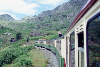 Auf der Neubaustrecke
Blick zurück auf den Zug im neuen Streckenabschnitt oberhalb des Stausees. Der Rechtsstreit um die geflutete Bahntrasse zog sich über einen Zeitraum von 18 Jahren und brachte der FR 1972 letztendlich eine beachtliche Entschädigungszahlung ein, die für den Bau der neuen Trasse gut gebraucht werden konnte. 
Schlüsselwörter: Wales , Ffestiniog Railway