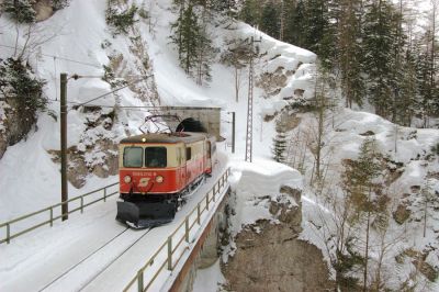 Winter in den Zinken
1099 010-9 bringt den einzigen planmäßig lokbespannten Zug des Vormittags zu Tal, aufgenommen am Nordportal des Erlaufklausetunnels. Auch die schroffen Felsen der Zinken sind an diesem Märzwochenende noch mit einer dicken Schneehaube verhüllt.
Schlüsselwörter: Mariazellerbahn , MzB , Bergstrecke , Südrampe , Zinken , 1099