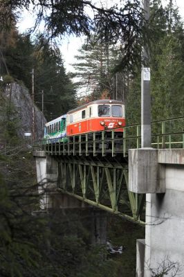 Der 6832 ist die einzige Talfahrt mit 1099 am Vormittag. Die Kienbach-Klaus-Brücke wäre mit dem Zug in Richtung St. Pölten bei geeigneter Lichtstimmung ein schönes Motiv von oben, zeigt sich doch auch der Ötscher im Hintergrund. Da mir das einerseits wegen der umherziehenden Wolken zu unsicher war und sich der im Vordergrund erkennbare Fahrleitungsmasten recht unvorteilhaft ins Bild drängt, entschied ich mich für eine Aufnahme von einem tieferen Standpunkt zwischen den Bäumen heraus.
Schlüsselwörter: Mariazellerbahn , MzB , Bergstrecke , Südrampe , 1099 ,  Kienbach-Klaus-Brücke