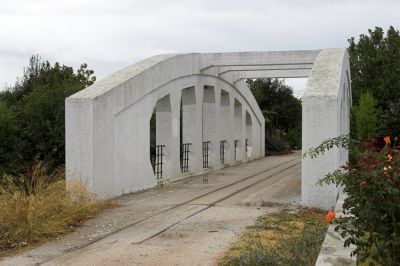 Die Vrychonas-Brücke
Die Brücke über den Vrychonas-Bach ist die älteste Stahlbetonbrücke Griechenlands und das markanteste Bauwerk in diesem Abschnitt. Bis zum Bau einer neuen Straßenbrücke diente sie dem Schienen- und Straßenverkehr.
Schlüsselwörter: Griechenland , Pilionbahn