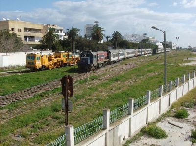 Ausfahrt aus Sousse
Der Schnellzug nach Tunis verlässt neben einer meterspurigen Plasser & Theurer - Gleisstopfmaschine den Bahnhof Sousse. Mit 130 km/h Höchstgeschwindigkeit sind dies die schnellsten Meterspurzüge der Welt.
Schlüsselwörter: Schmalspur in Tunesien