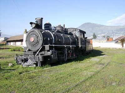 Ferrocarriles Ecuatorianos
Im Bahnhof Quito (Estacion Chimbacalle) steht die Dampflokomotive 45 als Denkmal vor einem geschlossenen Güterwagen und einem Personenwagen. 
