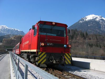 Ein Steuerwagenzug der Zillertalbahn wird von einer der Neubauloks gerade über die Rotholzer Innbrücke gezogen.
Schlüsselwörter: Wendezug , Zillertal