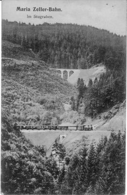 Die Nordrampe
Auf der mittleren Ebene der Nordrampe ist ein Zug mit einer Mh der ersten Serie bergwärts unterwegs, im Hintergrund ist der Sturzgrabenviadukt auf der oberen Ebene zu sehen. Postkarte aus der Zeit der Eröffnung der Bergstrecke

(Quelle: Sammlung E. Livingstone, Royston, UK)


Schlüsselwörter: Mariazellerbahn , MzB , Bergstrecke , Nordrampe